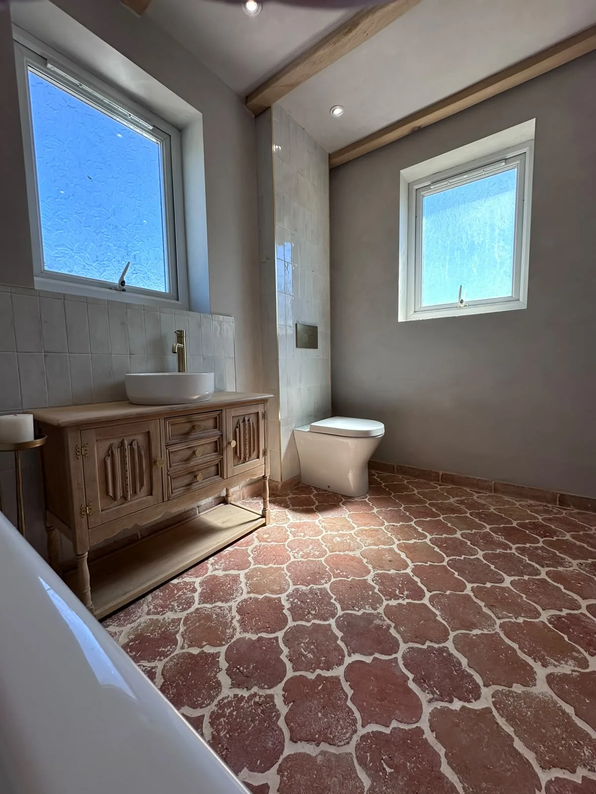 Bathroom renovation with antique timber vanity, brass tap, countertop basin and handmade terracotta floor tiles