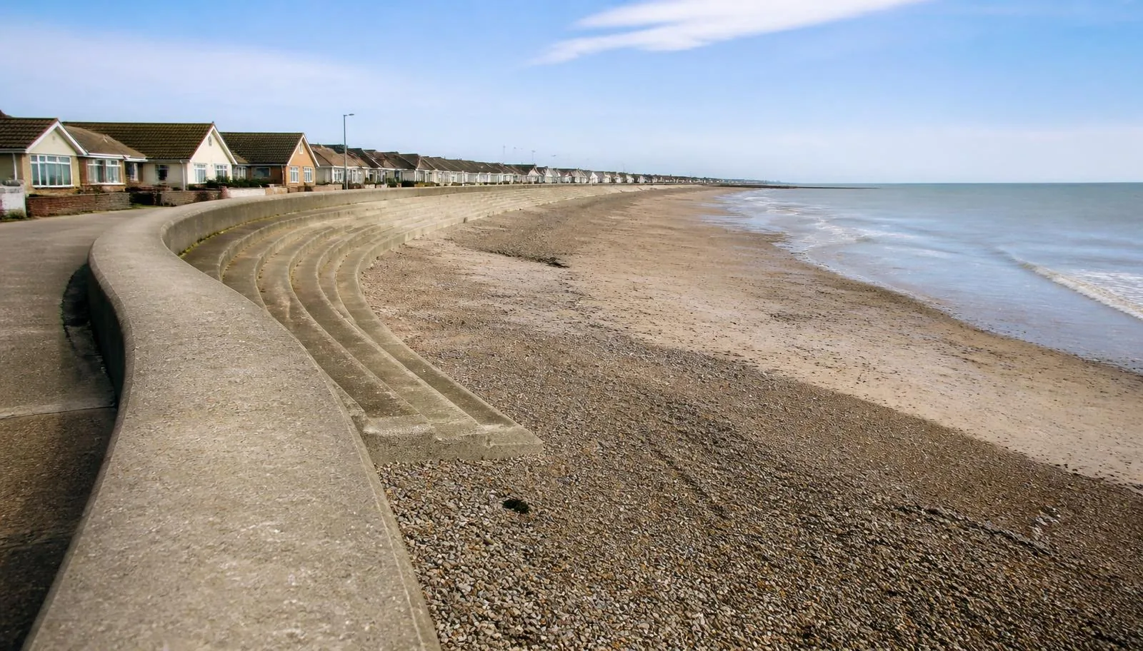 The curved sea wall and promenade at Cleveleys with seafront bungalows behind